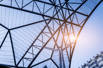 Fototapeta premium Structure of steel roof frame for building construction on sky background.