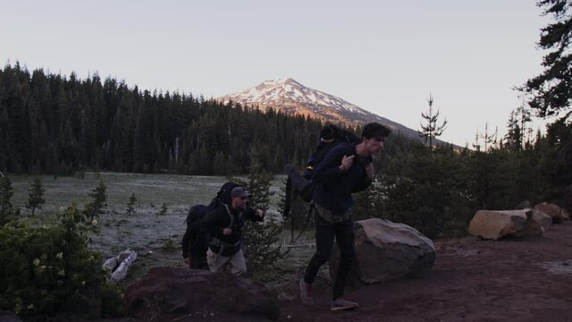 Three Backpackers Walking Up The Hill In Central Oregon With Mt Bachelor In The Background On An Early Morning - close up slowmo