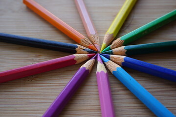 Naklejka premium circle center colored pencils on wooden table background. back to school concept