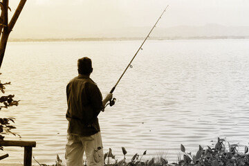 He was fishing with a hook on a lake.In the old image that look sad.