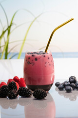 Fototapeta na wymiar a delicious looking glass of fruit juice with blueberries and a straw.healthy food concept.
