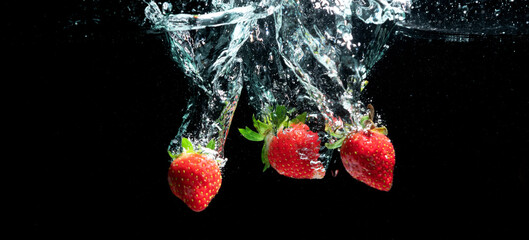 Fototapeta na wymiar strawberry falling into water