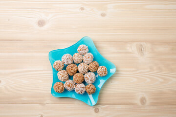 Obraz na płótnie Canvas balls of dried fruit sprinkled coconut shavings