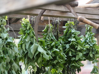 Saving summer.Medicinal herbal background.Bunches of mint and Melissa plants are dried under a canopy.