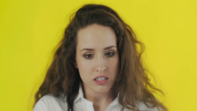 Portrait of discontent woman expressing aversion and demonstrating her disgust in Studio with yellow Background.