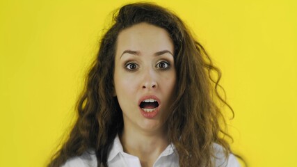 Portrait of shocked woman demonstrating her surprised in Studio with yellow Background.