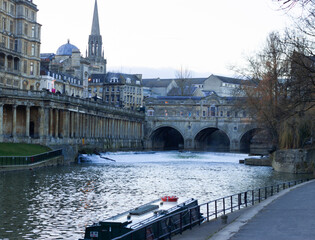 A scenic view of the historic district of Bath, UK featuring the Avon River, Bath Abbey and the Pulteney Bridge