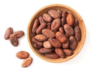 unpeeled cocoa beans in the wooden bowl, isolated on white background, top view