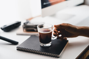 Hot coffee in a cup at the computer desk