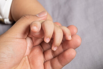 baby hand holding father hand
