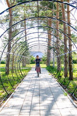 little cyclist rides through a tunnel in a park © vitec40