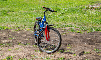 blue bicycle with a red fork stands on the road
