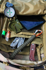 Fototapeta na wymiar Compass, knife and multitool in a backpack