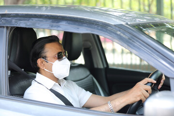 Man driving car with mask on. Protection against covid-19. Drive safely. 