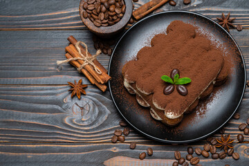 Classic tiramisu dessert on ceramic plate on wooden background