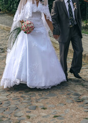 Fototapeta na wymiar Bride and groom walking on street