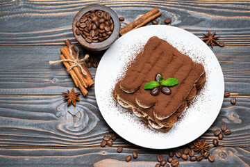 Classic tiramisu dessert on ceramic plate on wooden background