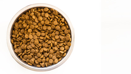 Dry Dog and Cat food.  Pile of kibbles in a metal food bowl. Top view on white backgound with copy space