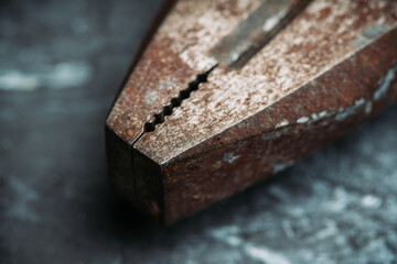 Old rusty pliers on the gray concrete background. Macro shot. Selective focus. Shallow depth of field.
