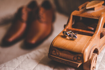 cuff links and shoes on a brown background
