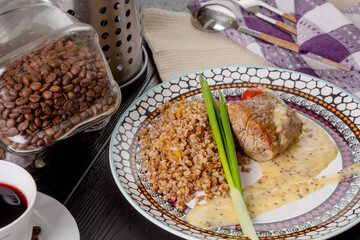 A piece of boiled beef with mushroom sauce and buckwheat