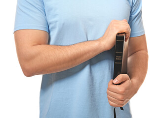 Young man with Bible on white background, closeup