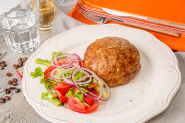 Chicken Kiev with vegetable garnish from tomato, salad, zucchini and fresh onion