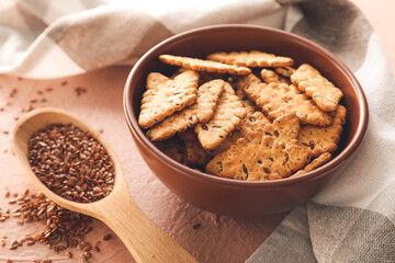 Bowl with cereal cookies and flax seeds on color background