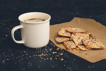 Cereal cookies and cup of coffee on dark background