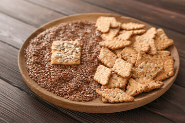 Plate with cereal cookies and flax seeds on wooden background