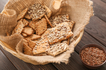 Basket with cereal cookies and flax seeds on wooden background