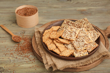 Plate with cereal cookies and flax seeds on wooden background