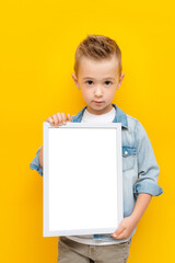 Serious kid holding white frame with copy space for text certificate or diploma