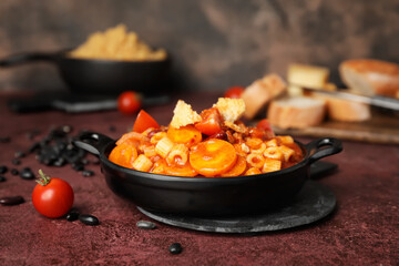 Dish with tasty pasta and beans on table