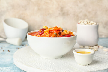 Bowl with tasty pasta and beans on table