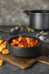 Bowl with tasty pasta and beans on table