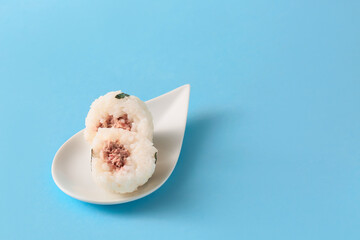 Plate with traditional Japanese onigiri on color background