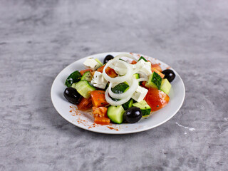 Vegetable salad of cucumbers, tomatoes and onions on a plate