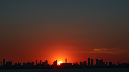 Breathtaking view of Miami skyline sunset. Sun between buildings. Taken from the Ocean
