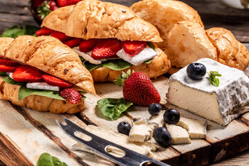 croissants with soft cheese and fresh strawberries. Breakfast set. Food recipe background. Close up
