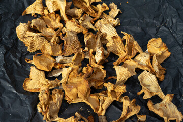 dried mushrooms on black crumpled paper