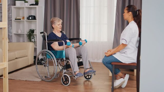 Old lady in wheelchair doing physical rehabilitation with nurse. Training, sport, recovery and lifting, old person retirement home, healthcare nursing, health support, social assistance, doctor and