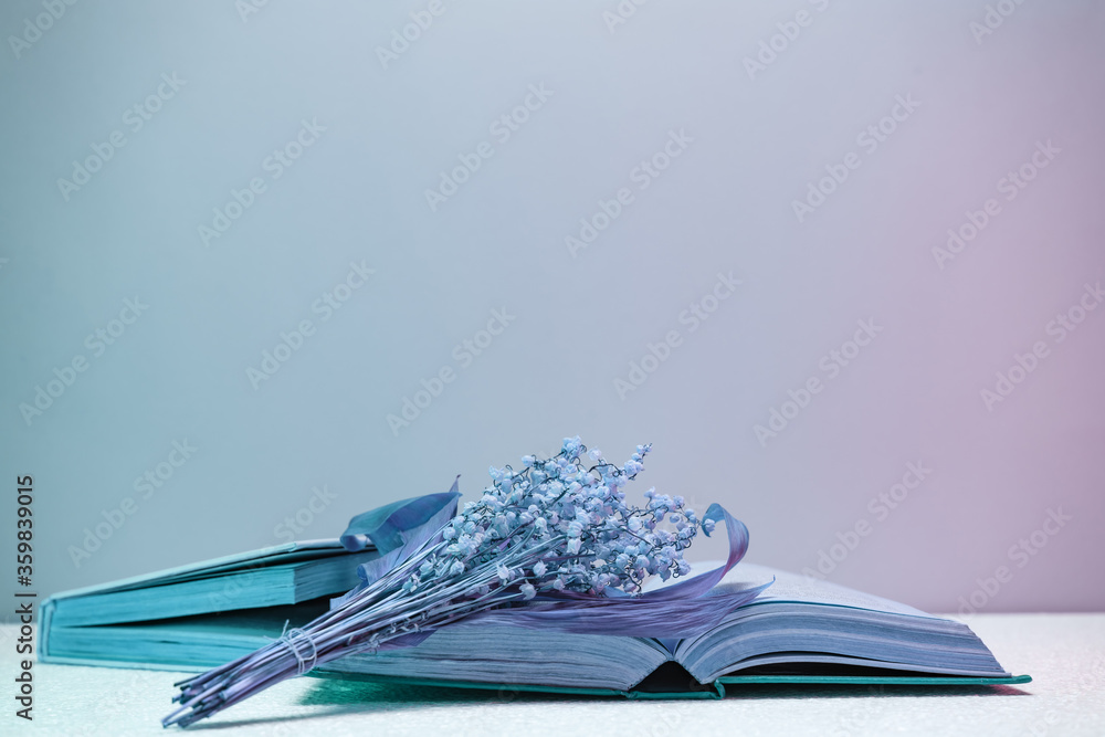 Poster Close up Beautiful open book and flowers  in neon light. Minimalism retro style concept. 80s. Background pattern for design.