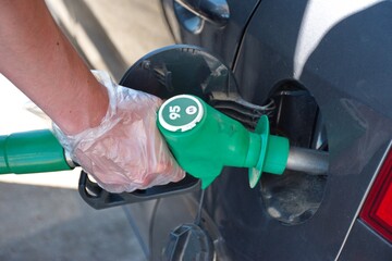 Man's hand filling petrol at station