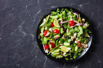 chicken veegies salad in a black bowl