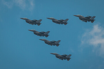 Fototapeta na wymiar Modern fighter aeroplanes flying in the V formation over the blue skies.