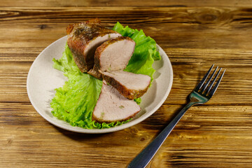 Tasty baked pork with spices on a wooden table