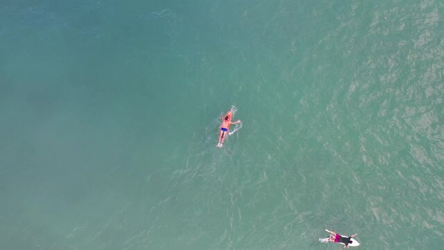 imagem a&eacute;rea de bela praia com pessoas praticando surf, bodyboard, stand up e se banhando 