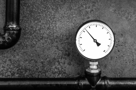 pressure gauge measuring device on a gas factory background close-up in gray tones