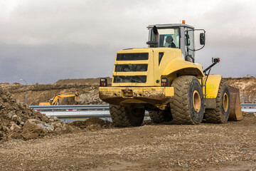 Obraz premium Yellow excavator moving earth at a construction site